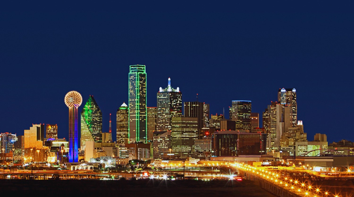 The Dallas skyline at dusk, with Reunion Tower lit against a deep blue sky